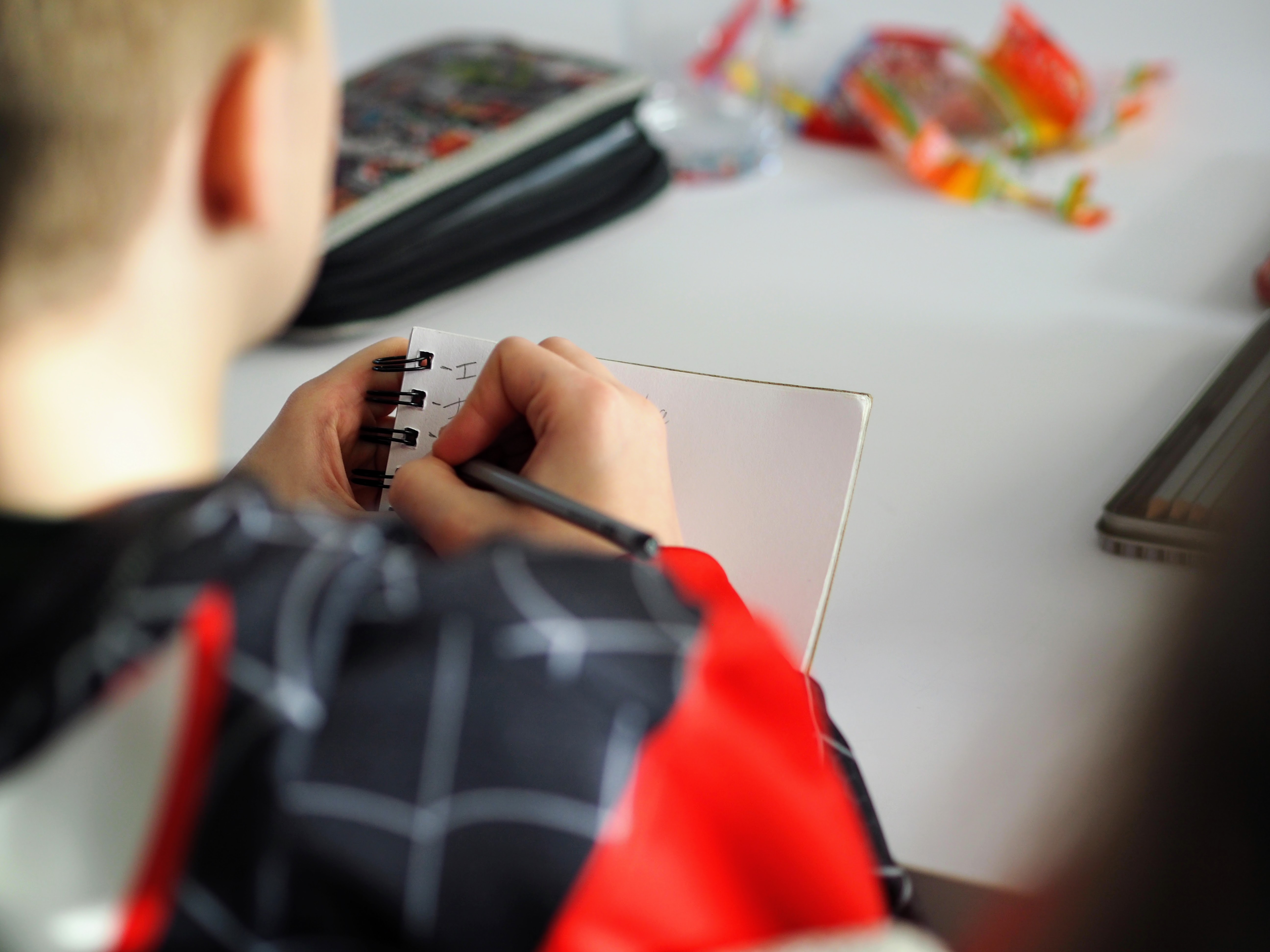 A student writes down a list of items on a notepad.