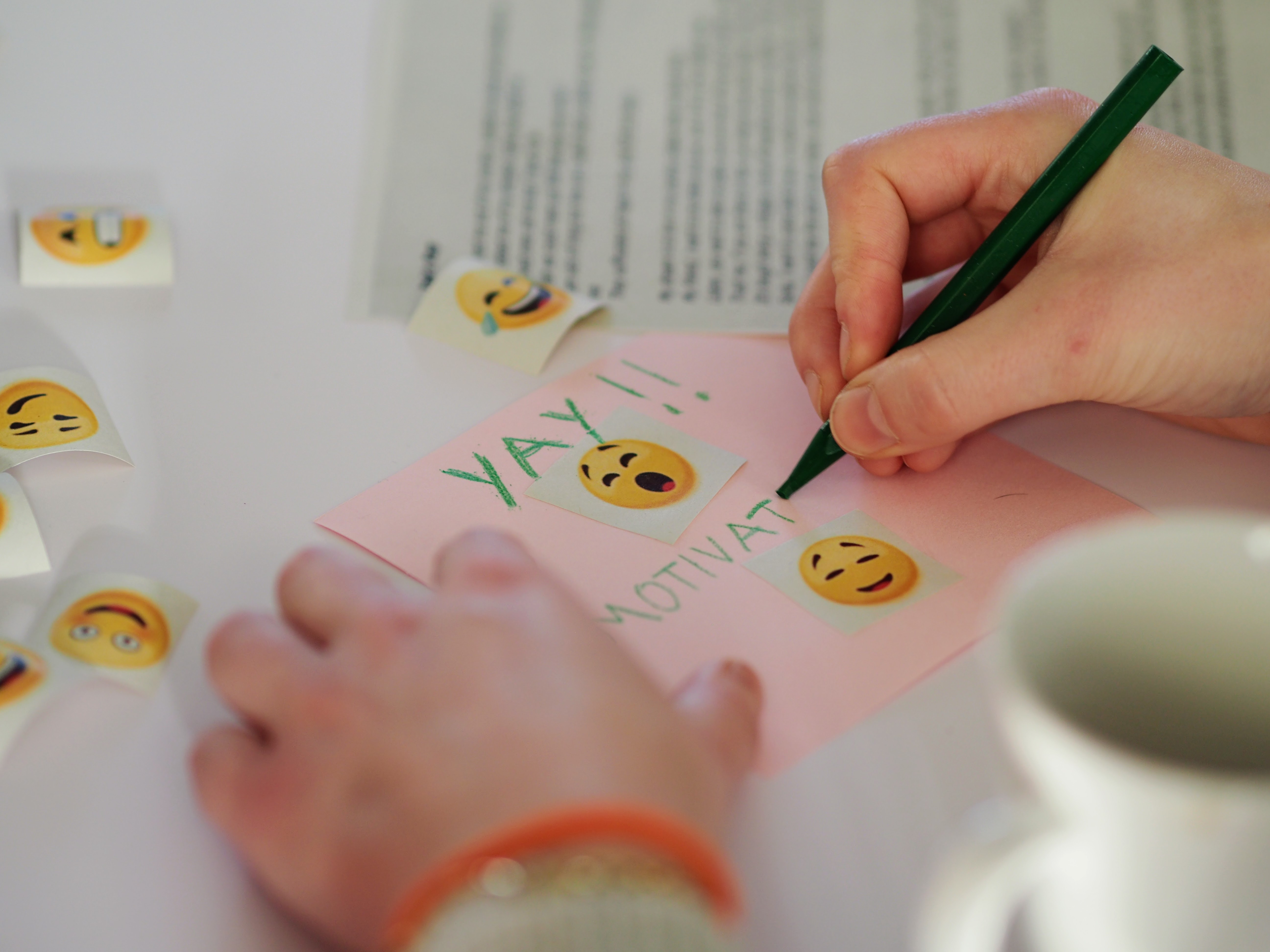 A participant creating a mood mosaic using a square of paper and coloured pencil crayons.